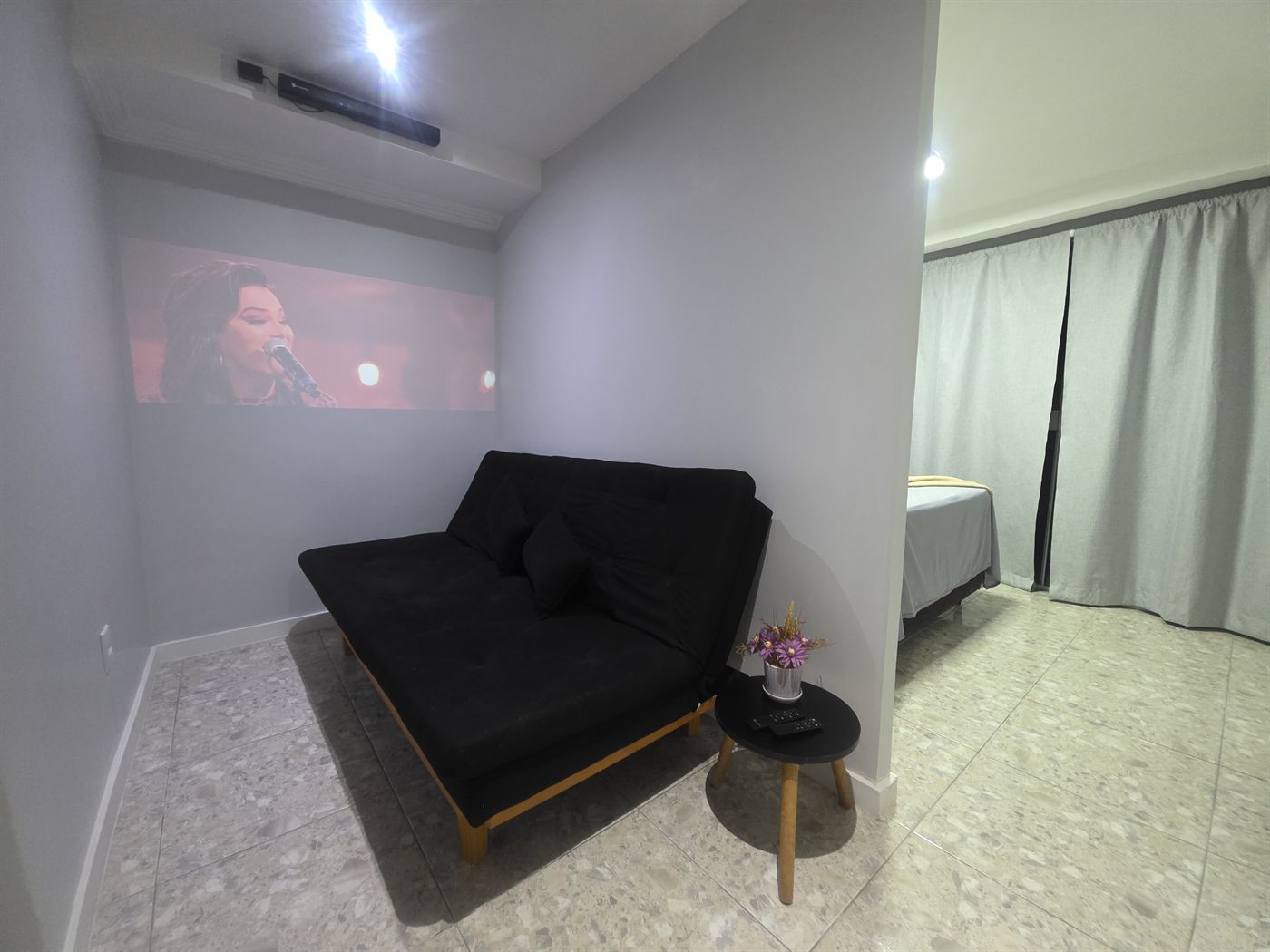 Sala de estar com projetor na Suite Rooftop em Macaé
