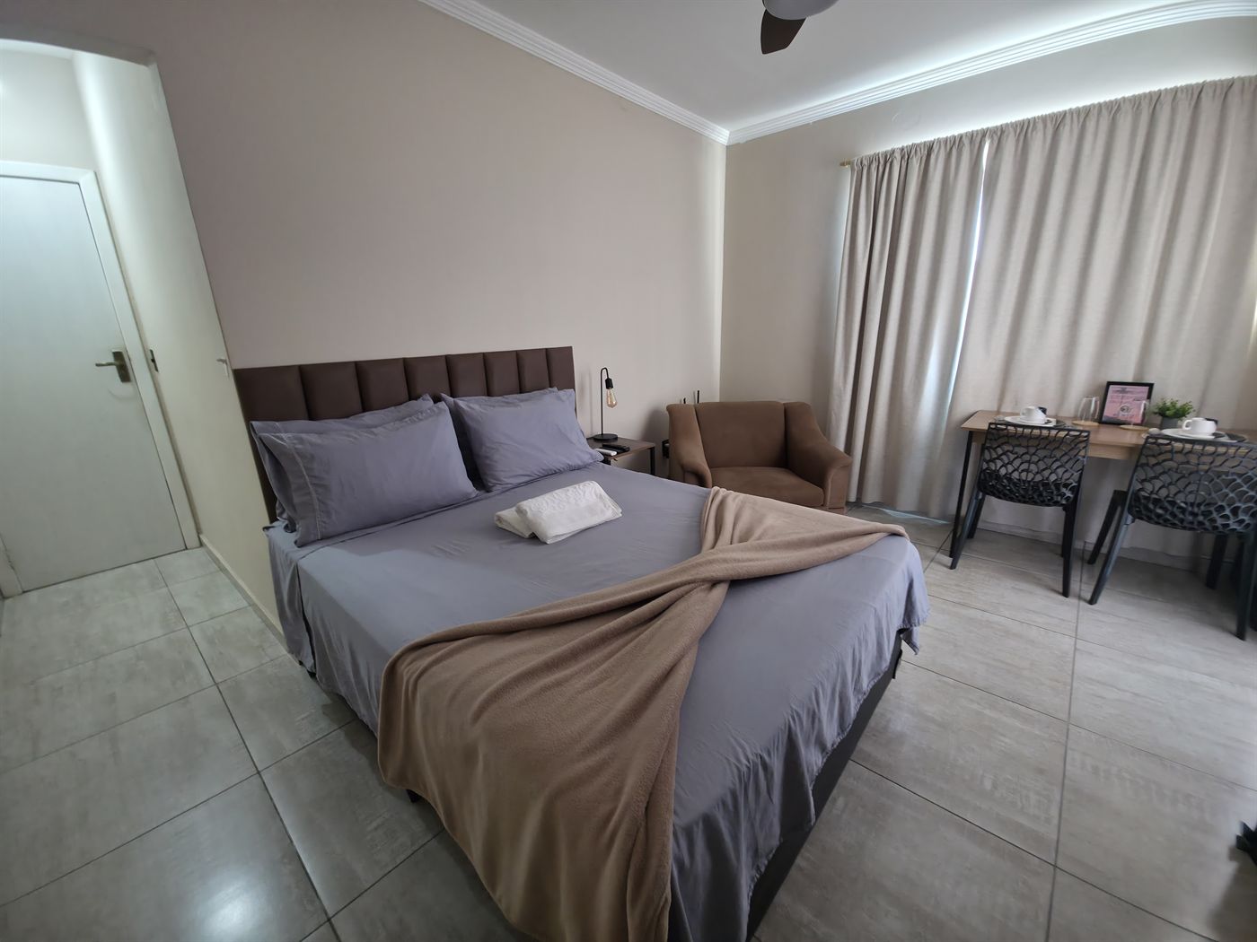 Cama de casal e área de estar no Quarto Comfort em Macaé